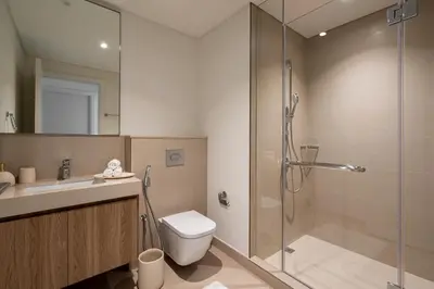 a bathroom with a shower and a toilet and a sink at TH-Homes designed apartment Downtownview in Dubai
