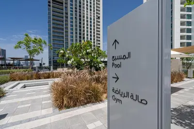 a sign on a pole in front of a building at TH-Homes designed apartment Downtownview in Dubai