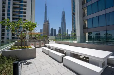 a white table and benches on a building at TH-Homes designed apartment Downtownview in Dubai