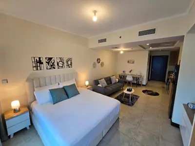 a bedroom with a large white bed and a couch at Click Stay - JLT - Entire Studio & Balcony Lakes view Apartment -NA in Dubai