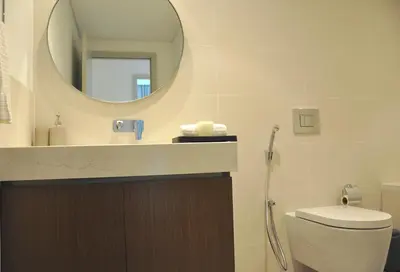 a bathroom with a sink and a mirror and a toilet at Sea Breeze Oasis in Dubai