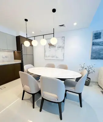 a dining room with a white table and chairs at Sea Breeze Oasis in Dubai