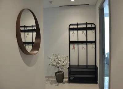 a mirror and a vase with flowers in a hallway at Sea Breeze Oasis in Dubai
