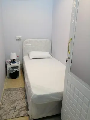 a small bed in a room with a white bed frame at MOE Hostel By PHM in Dubai