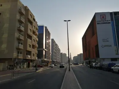 a street with cars driving down a city street with buildings at MOE Hostel By PHM in Dubai
