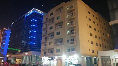 a tall building with blue lights on it at night at MOE Hostel By PHM in Dubai