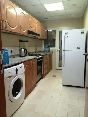 a kitchen with a refrigerator and a washing machine at MOE Hostel By PHM in Dubai
