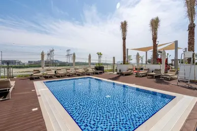 a swimming pool with lounge chairs and palm trees at GuestReady - Urban Retreat in Downtown in Dubai