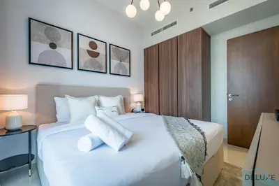 a bedroom with a large white bed with two pillows at Exclusive Rate 1BR with Partial Burj Khalifa Views by Deluxe Holiday Homes in Dubai