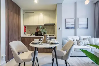 a kitchen and living room with a table and chairs at Exclusive Rate 1BR with Partial Burj Khalifa Views by Deluxe Holiday Homes in Dubai