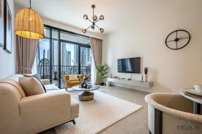 a living room with a couch and a tv at Beautiful 1BR in Creek Edge Tower 2, Dubai Creek Harbor by Deluxe Holiday Homes in Dubai