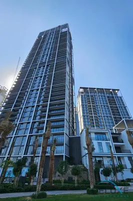 a tall building with palm trees in front of it at Beautiful 1BR in Creek Edge Tower 2, Dubai Creek Harbor by Deluxe Holiday Homes in Dubai