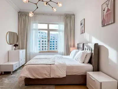 a bedroom with a large bed and a window at Bright 2BR Apartment with Garden View - Palm Jumeirah in Dubai
