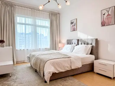 a bedroom with a large bed and a large window at Bright 2BR Apartment with Garden View - Palm Jumeirah in Dubai