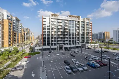 an aerial view of a parking lot with a large building at Comfy 1BR in Azizi Riviera 8, Al Merkadh by Deluxe Holiday Homes in Dubai