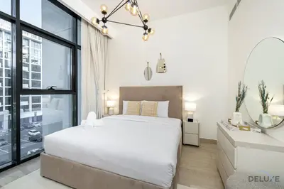 a bedroom with a large white bed and a window at Comfy 1BR in Azizi Riviera 8, Al Merkadh by Deluxe Holiday Homes in Dubai