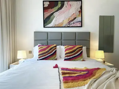 a bedroom with a white bed with two pillows at Vibrant 1BR Apartment with Marina & Ocean View in Dubai