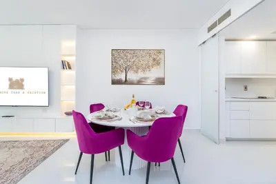 a dining room with a table and purple chairs at High class apartment in Dubai
