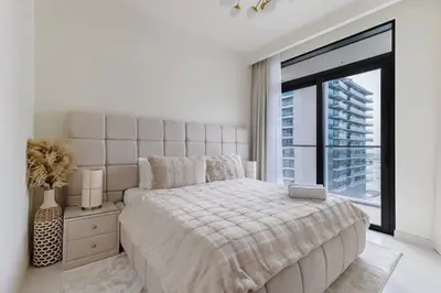 a white bedroom with a large bed and a large window at Goldbest - 2bdr Marina view in Dubai