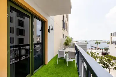 an apartment balcony with a view of the water at Goldbest La Mer - Luxury 1 bdr Apartment with Beachfront Pool in Dubai