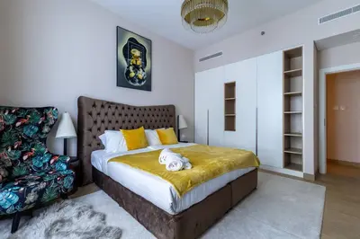 a bedroom with a bed with a stuffed animal on it at Goldbest La Mer - Luxury 1 bdr Apartment with Beachfront Pool in Dubai