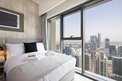 a bedroom with a large bed and a large window at SmartStay at Burj Royale - Unique Downtown Dubai City Views - Brand New Luxury Apartments in Dubai