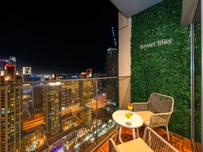 a balcony with a table and chairs and a green wall at SmartStay at Burj Royale - Unique Downtown Dubai City Views - Brand New Luxury Apartments in Dubai