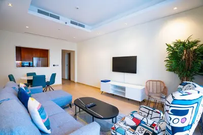 a living room with a blue couch and a tv at RH- Elevated Living, Modern 1BR Oasis at RP Heights walk away to Dubai Mall in Dubai
