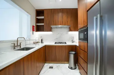 a kitchen with wooden cabinets and a stainless steel refrigerator at RH- Elevated Living, Modern 1BR Oasis at RP Heights walk away to Dubai Mall in Dubai
