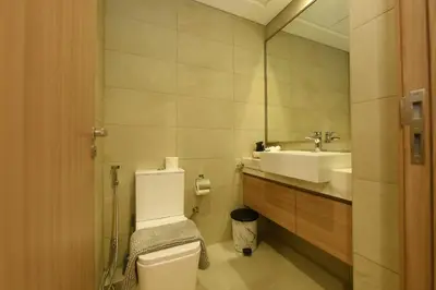 a bathroom with a toilet and a sink and a mirror at Stylish and Modern Studio at Azizi Riviera - Dubai in Dubai