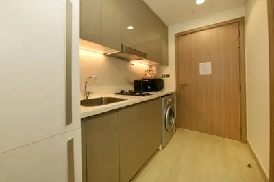 a kitchen with a sink and a dishwasher next to a door at Stylish and Modern Studio at Azizi Riviera - Dubai in Dubai