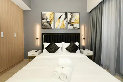 a bedroom with a large white bed with two pillows at Stylish and Modern Studio at Azizi Riviera - Dubai in Dubai
