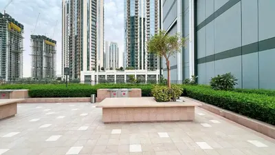 a courtyard in a city with tall buildings at Bright 2BR with Pool & Creek Views in Dubai