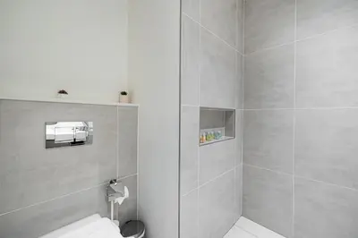 a bathroom with a toilet and a shower at Bright 2BR with Pool & Creek Views in Dubai