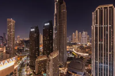 a city skyline at night with tall buildings at Luxury 3BHK, Burj Khalifa & Dancing fountain view in Dubai