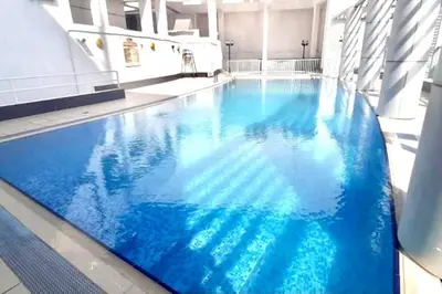 a large blue swimming pool in a building at RH - Spacious studio, near Dubai Mall, Downtown in Dubai