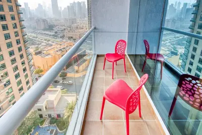 a balcony with pink chairs on top of a skyscraper at RH - Spacious studio, near Dubai Mall, Downtown in Dubai