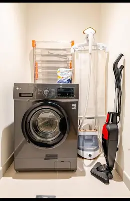 a washing machine in a room with a vacuum at Exquisite 1-Bedroom with Pool Scenery in Dubai Creek Harbour in Dubai