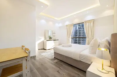 a white bedroom with a bed and a window at Luxury 4-Bedroom with Maids Room, Marina and Ain Dubai Views in Dubai