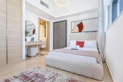 a bedroom with a white bed and a bathroom at Holiday Studio in JVC 2408, Dubai in Dubai