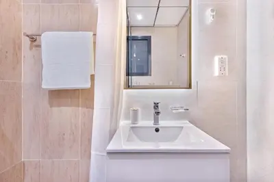 a bathroom with a white sink and a mirror at Holiday Studio in JVC 2408, Dubai in Dubai