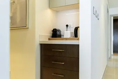 a kitchen with wooden cabinets and a counter top at Sleeps 8 Private Cinema World Island Views in Dubai