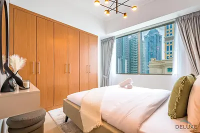 a bedroom with a bed and a large window at Luxury 3BR in Ocean Heights, Dubai Marina by Deluxe Holiday Homes in Dubai