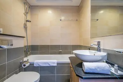 a bathroom with a sink and a tub and a toilet at Luxury 3BR in Ocean Heights, Dubai Marina by Deluxe Holiday Homes in Dubai
