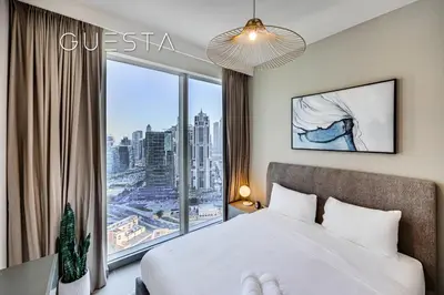 a bedroom with a bed and a large window at Forte Tower - Dubai Fountain View, Downtown Dubai in Dubai