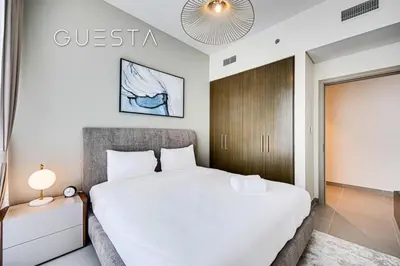 a bedroom with a white bed and a sign on the wall at Forte Tower - Dubai Fountain View, Downtown Dubai in Dubai