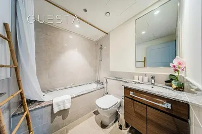 a bathroom with a toilet and a sink and a mirror at Forte Tower - Dubai Fountain View, Downtown Dubai in Dubai
