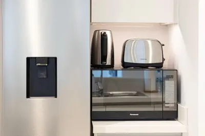 a microwave on a shelf next to a refrigerator at Burj Khalifa View & Dubai Mall Connection in Dubai