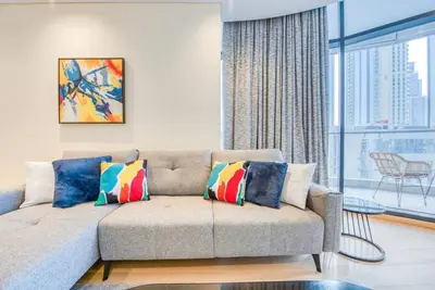 a living room with a couch and a large window at RH - Beautiful & Spacious furnished 01 BR, Walk away from Dubai Mall in Dubai