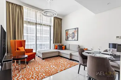 a living room with a couch and a table at WelHome - Charming Breathtaking 1BR Apt. In Damac Hills in Dubai
